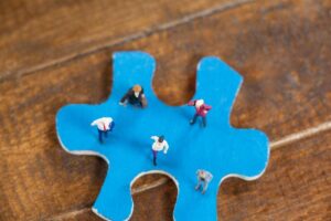 auf einem Puzzle Teil stehen kleine Figuren